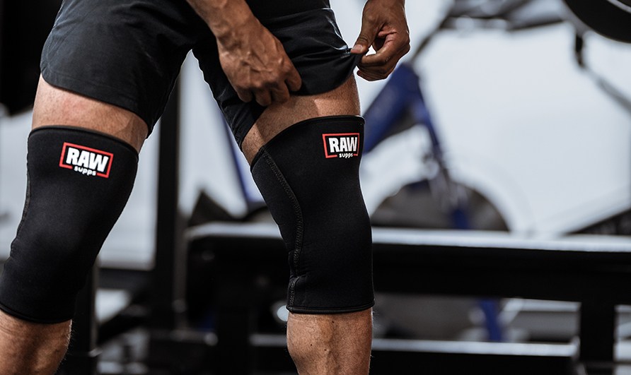 Henkiln jalat lantiosta pohkeisiin, polvissa RAW Supps Knee Sleeves 7 mm.